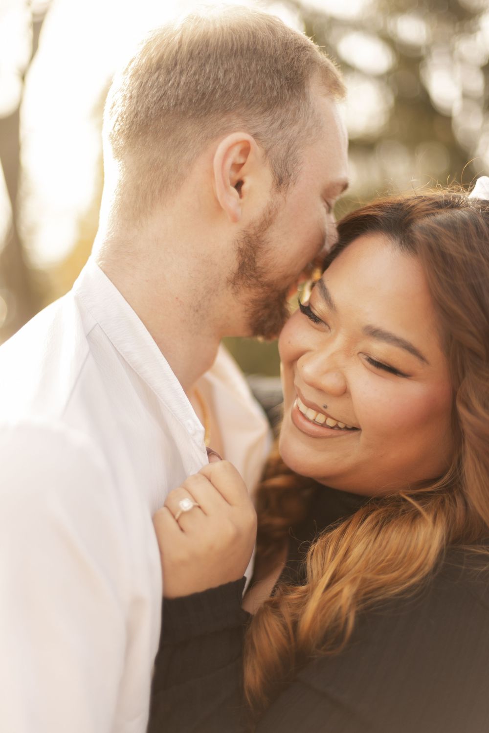 Intimate portrait of a couple sharing a tender moment in warm sunset lighting.