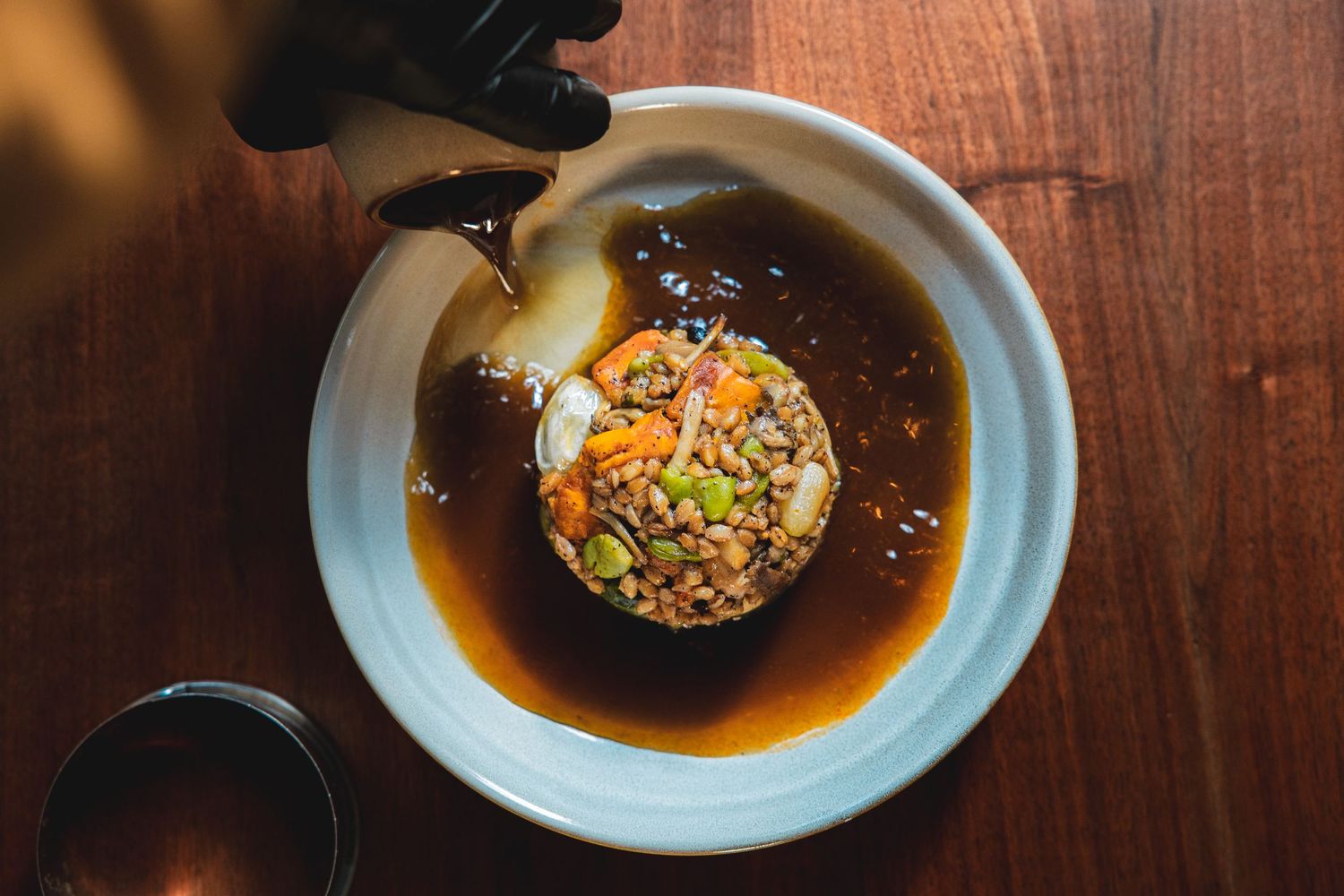 An elegant Asian-inspired rice dish served in a ceramic bowl with dark sauce.