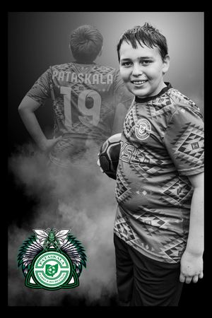 Black and white sports photo showing a youth player wearing a jersey, with a green team emblem in the lower corner.