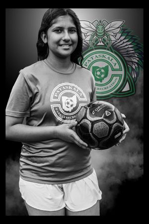 Soccer player smiles while posing with ball and green club logo in black and white photo series.
