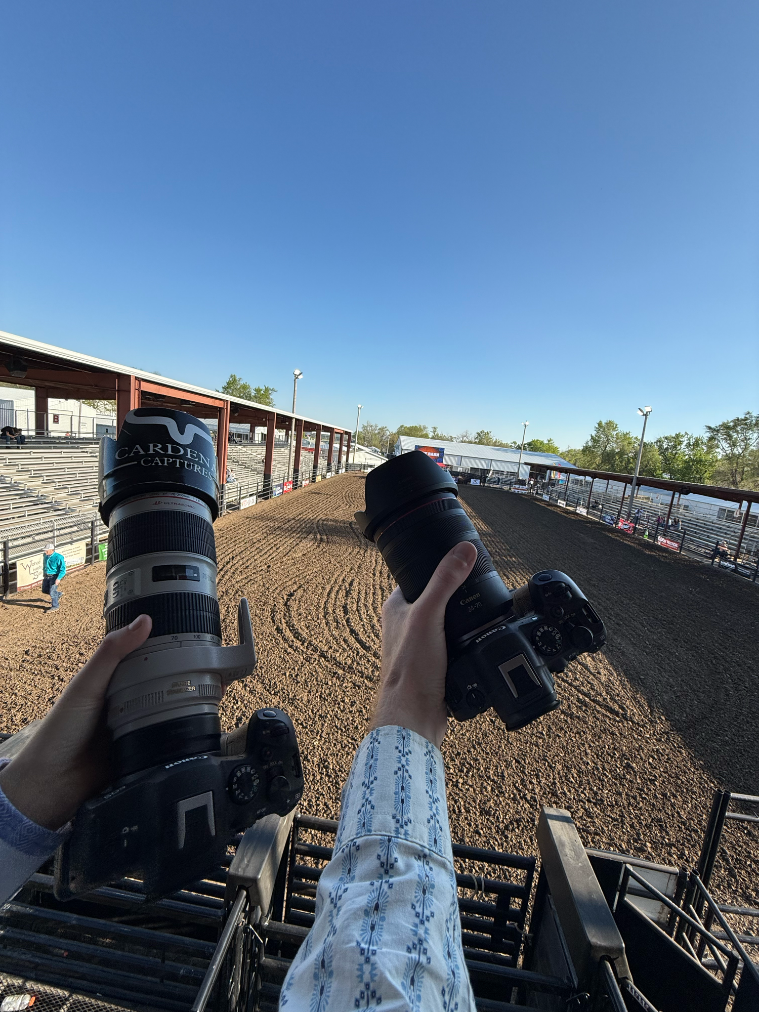 View of a dirt rodeo arena ground through black camera or video equipment.