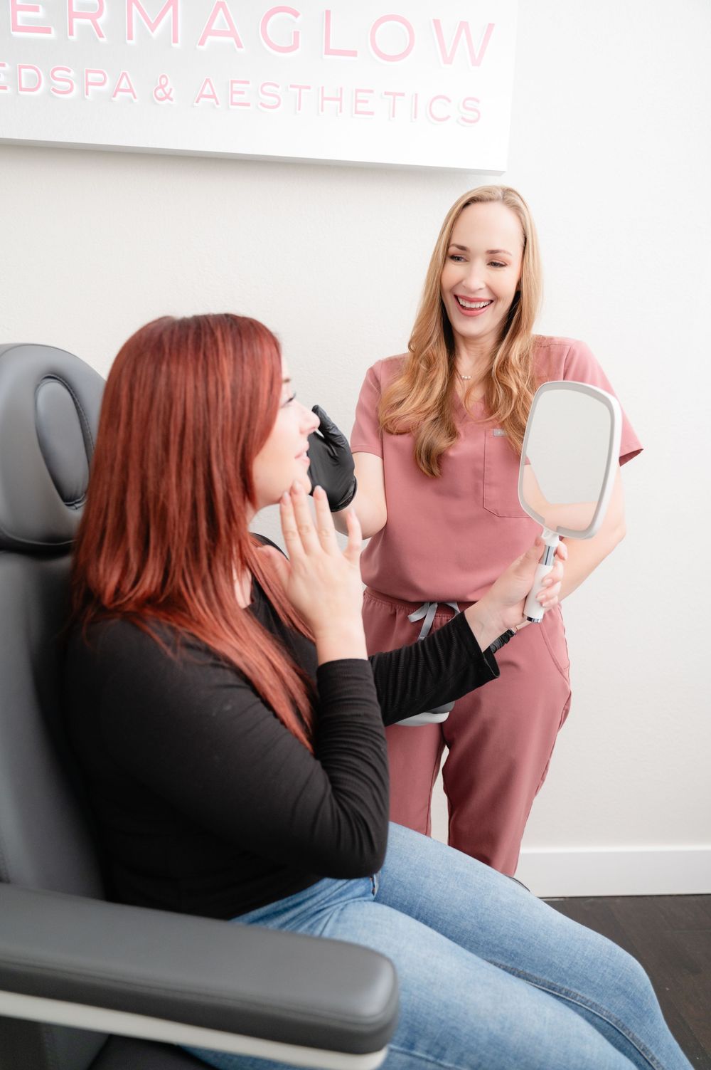 A medical aesthetics consultation session shows a staff member in pink scrubs discussing treatment with a client in a chair.
