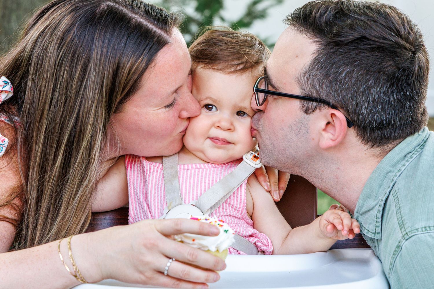 Intimate family moment captured outdoors with soft natural lighting.