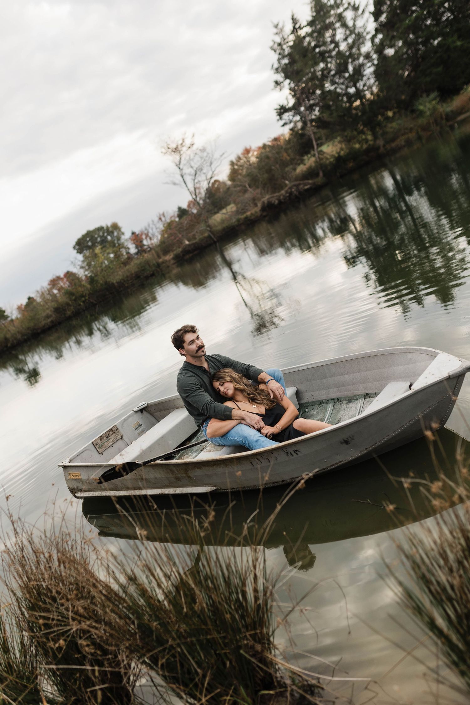 A sequence showing a boat flipping over in a lake with reeds along the shoreline during an overcast day.