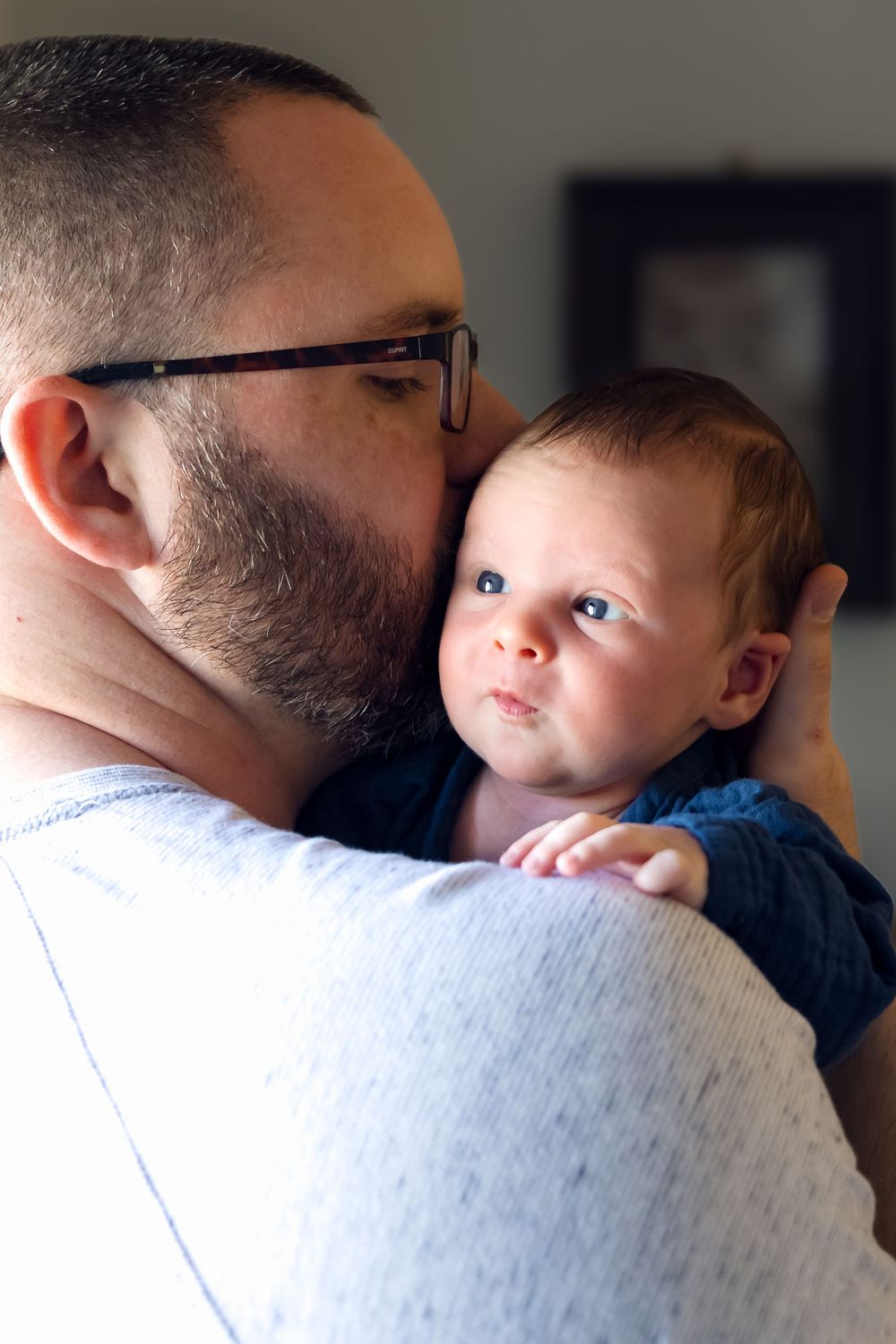Dad snuggles baby boy propped up on his shoulder during a photography newborn session in Jefferson, Ga.