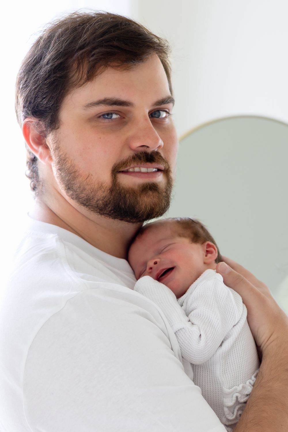 Dad snuggles baby girl on his chest during a photography newborn session in Athens, Ga.