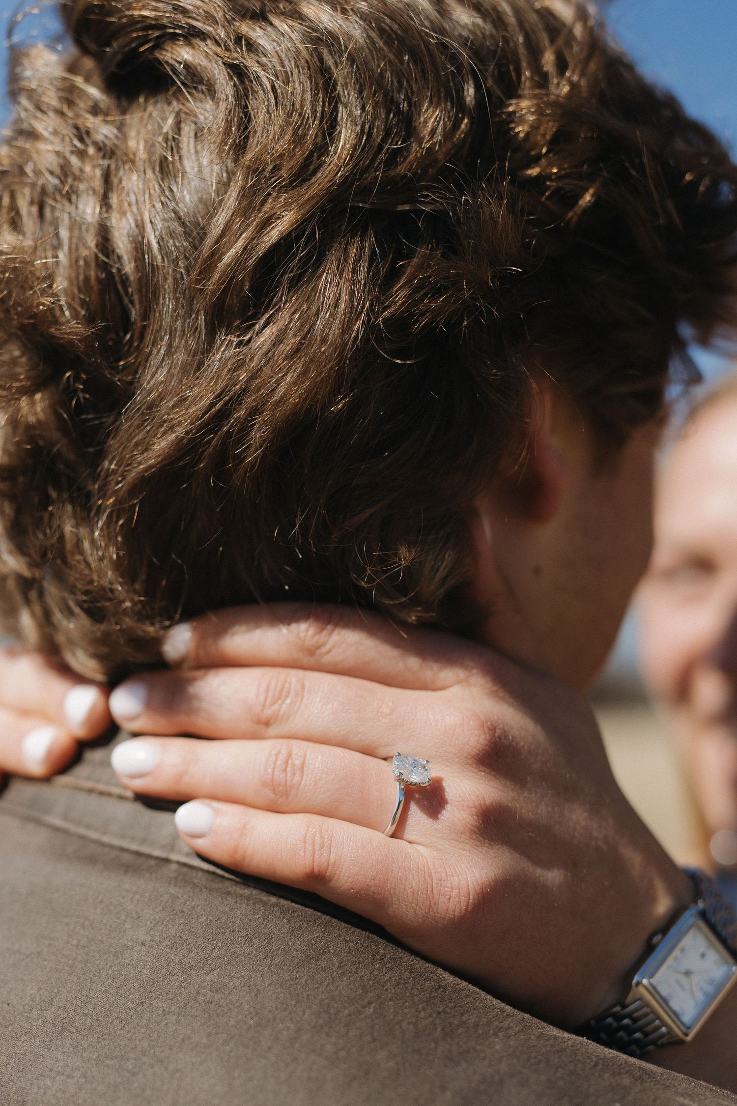 A close-up sequence shows a diamond engagement ring being placed on a finger against a blurred background.