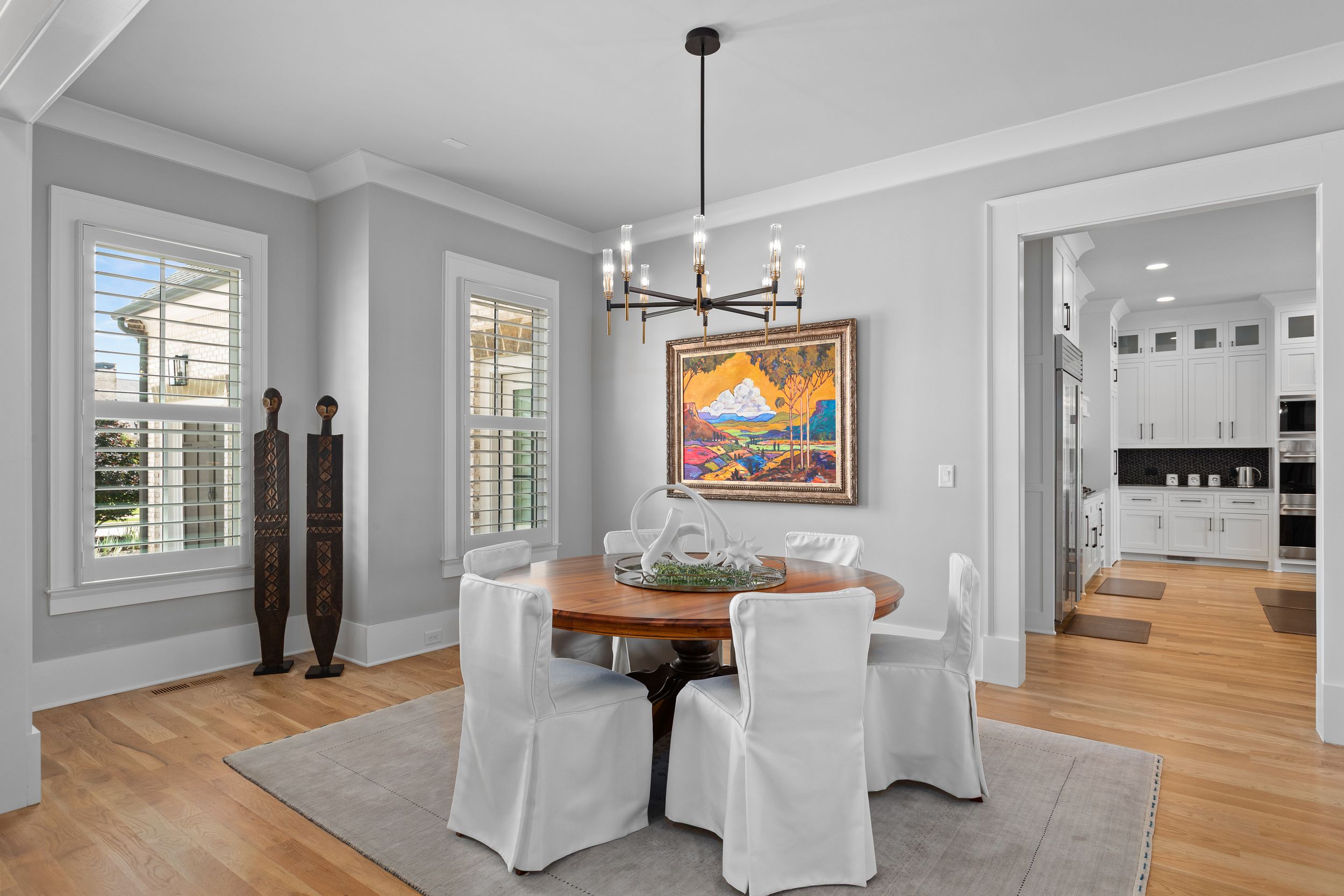 Modern dining room, showing various rooms of a modern home interior with white walls, hardwood floors and elegant decor. Real estate photo.