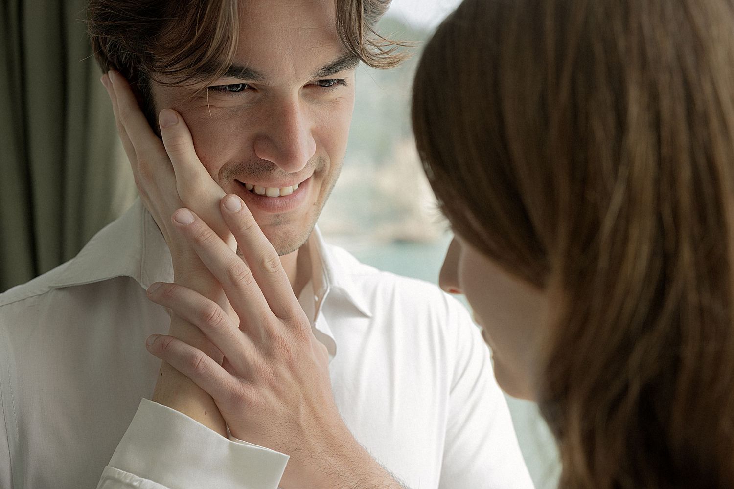 Two people engaged in intimate conversation in bright indoor setting.