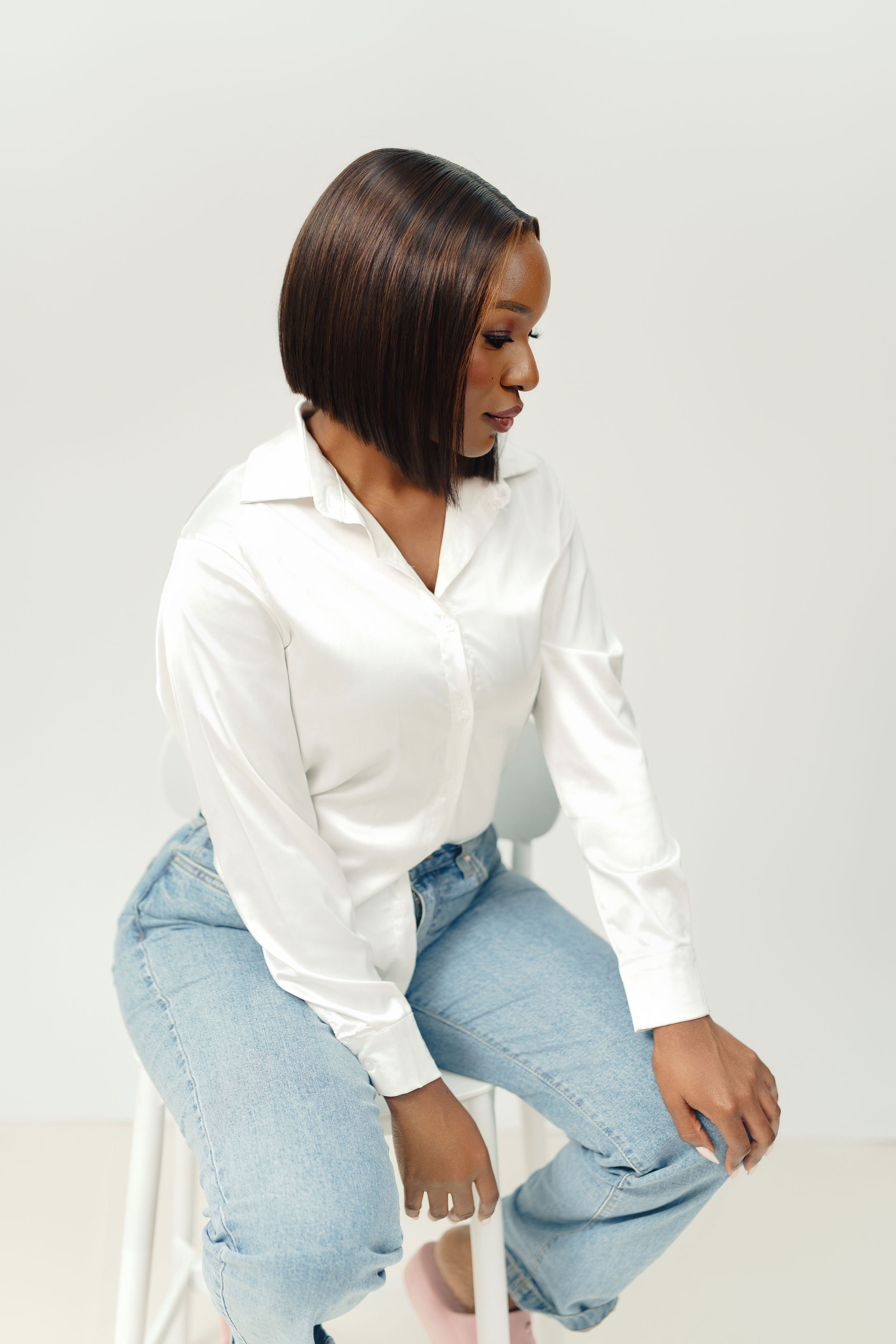 Person wearing white button-up shirt and light blue jeans poses against white background in three different angles.