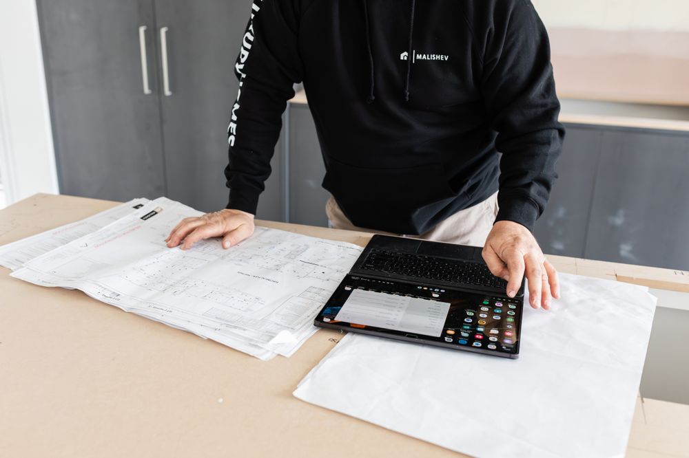 Construction planning session with blueprints and materials laid out on white surface.