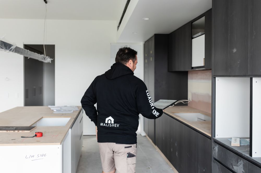 Interior renovation in progress showing dark wall panels and white ceiling installation.