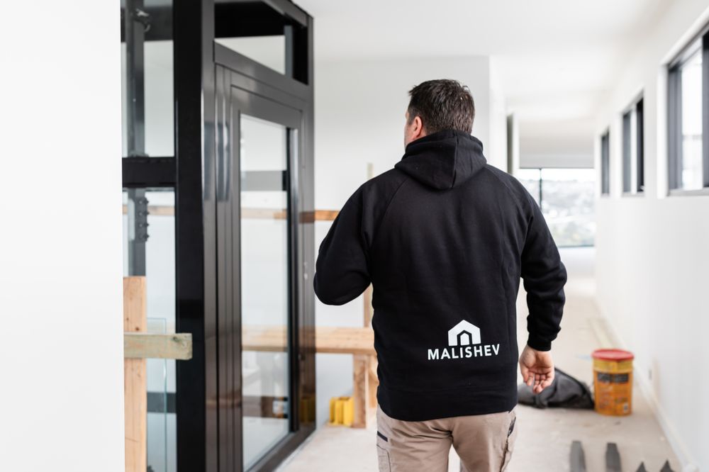 Professional inspector examines interior construction details of a modern building hallway.