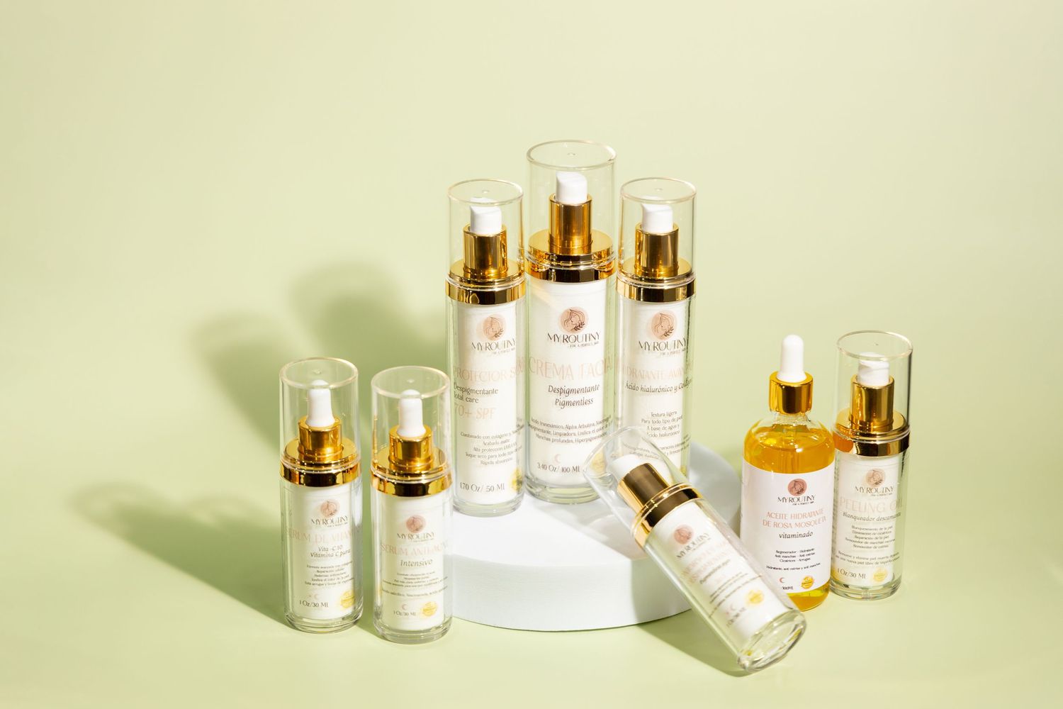 Collection of luxury skincare products displayed on light green background with gold accents.