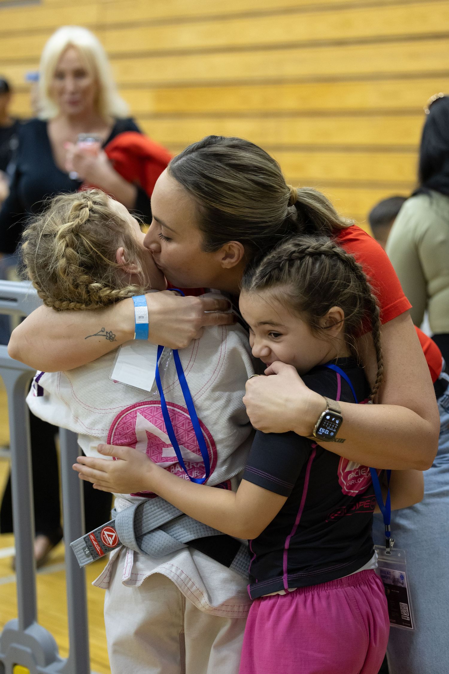 Athletes share emotional hugs and embraces mother after a competition at a martial arts tournament.