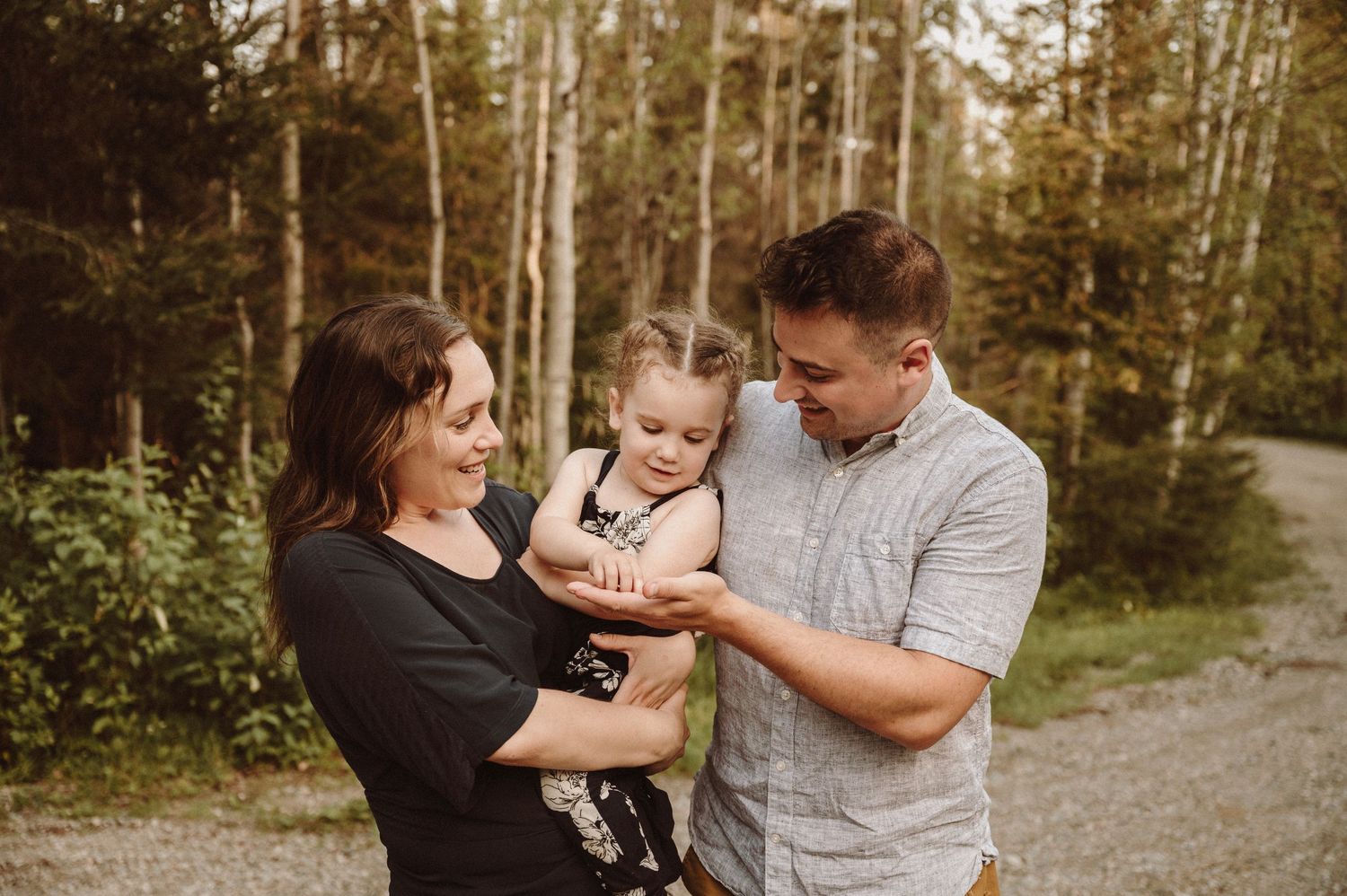Three people having a tender moment together outdoors.