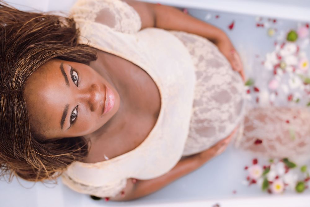 Maternity milk bath portrait of African American with pastel floral elements captured in Tracy CA photography session