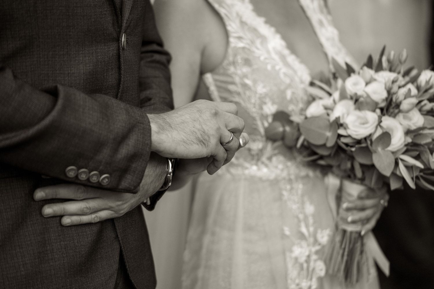 Close-up of hands exchanging rings during an intimate wedding ceremony.
