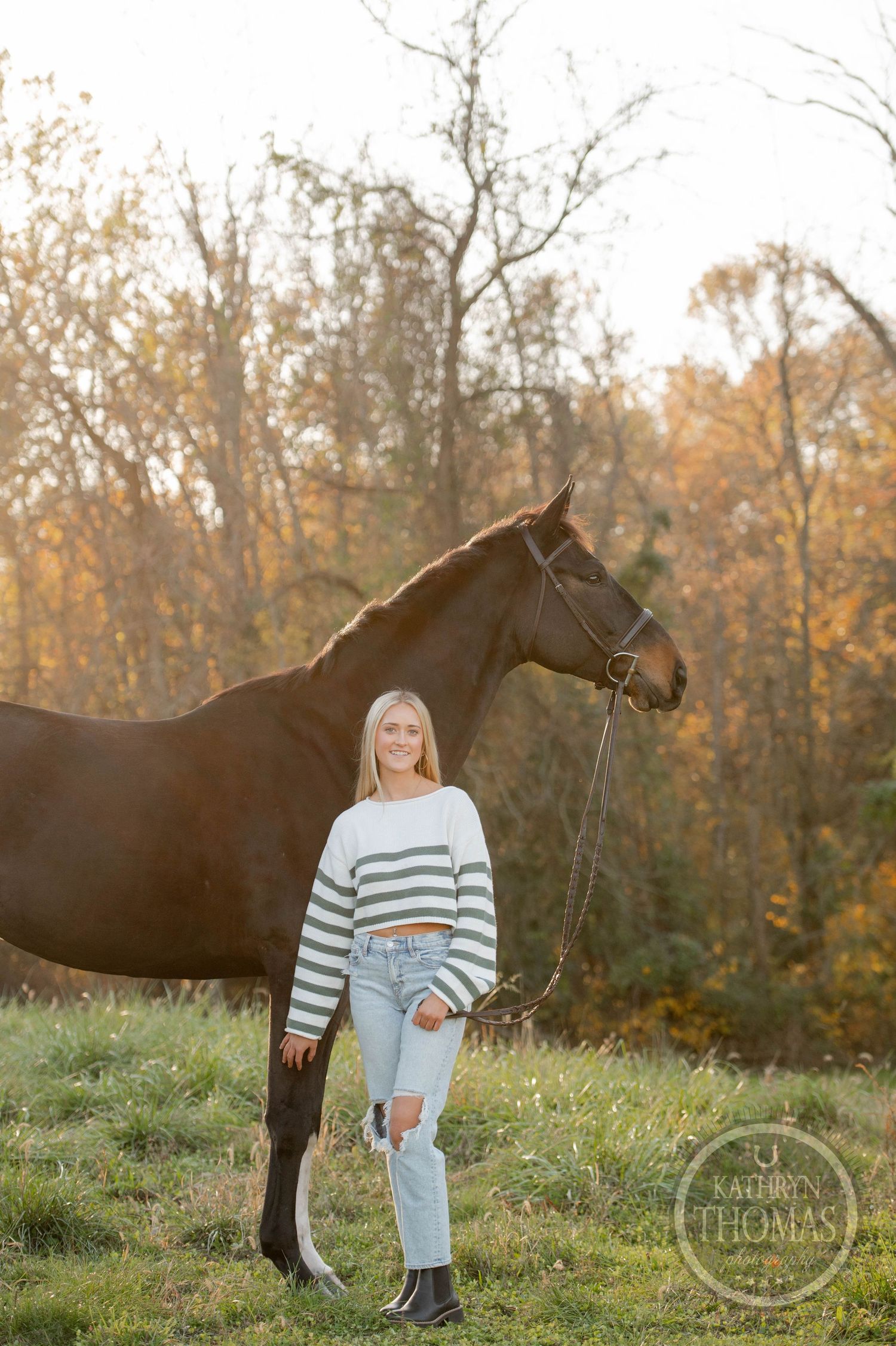 Horse and companion pose in fall setting with backlit trees and golden light.