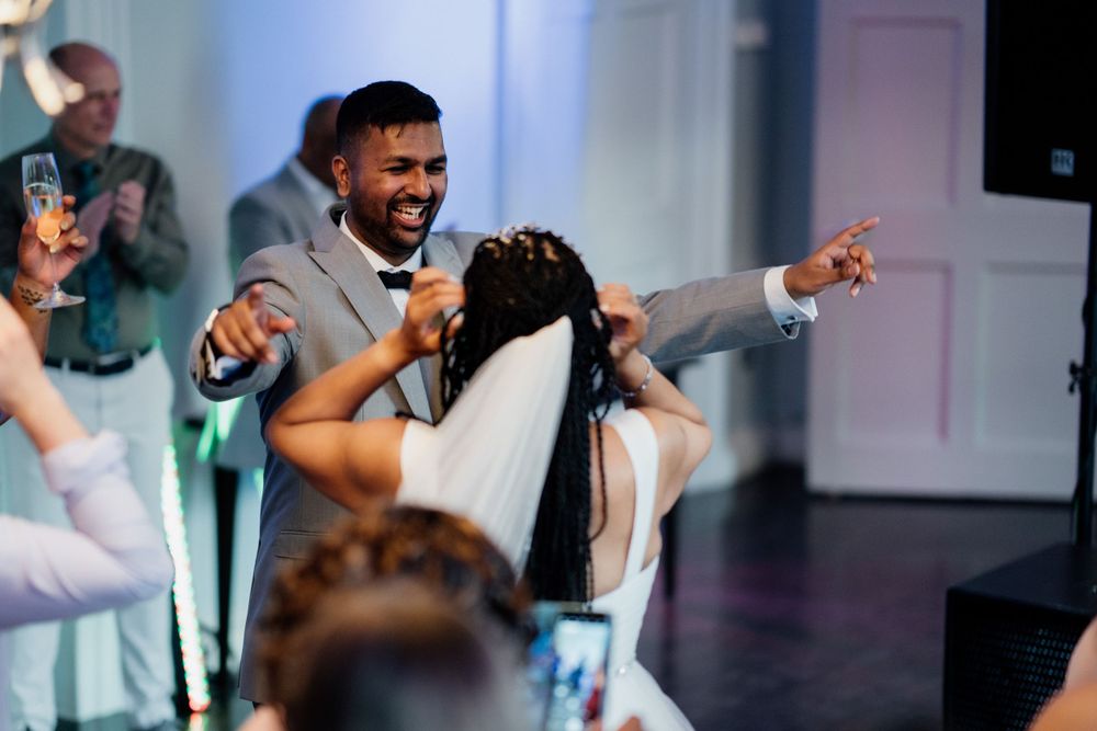 A celebration at a wedding reception venue with dancing and laughter on the dance floor.
