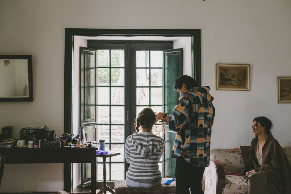 People gathered in a room with French doors and framed artwork on the walls.