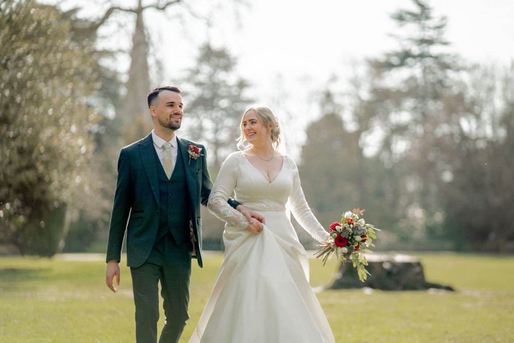 A couple shares a joyful moment together in a sunny garden setting on their wedding day.