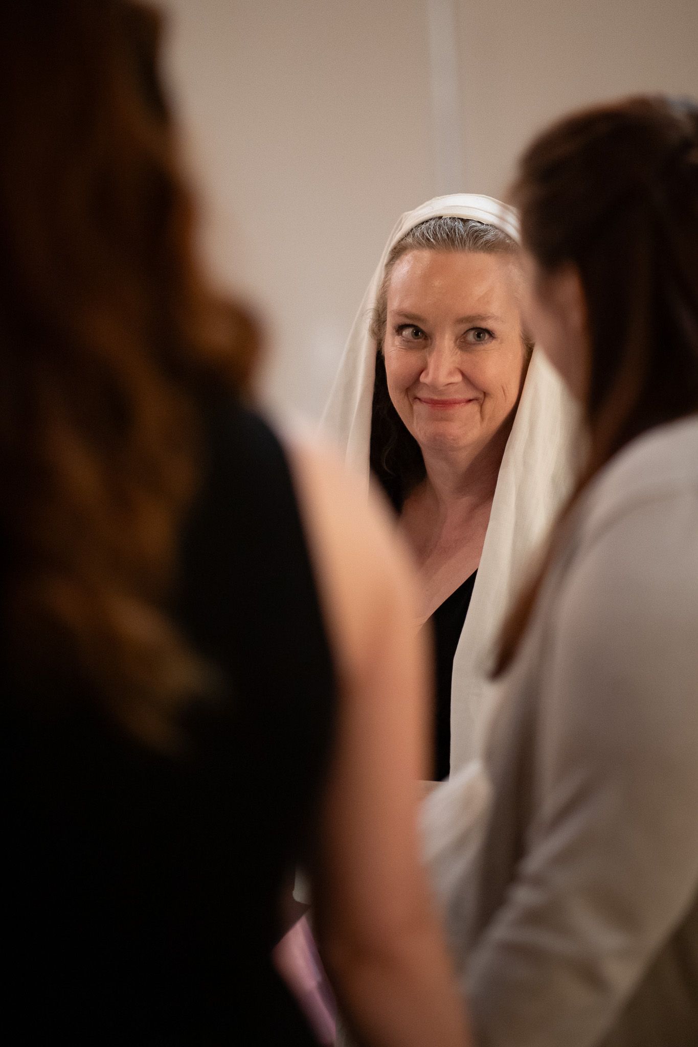 A candid moment captured between people in white and black attire inside a church setting.