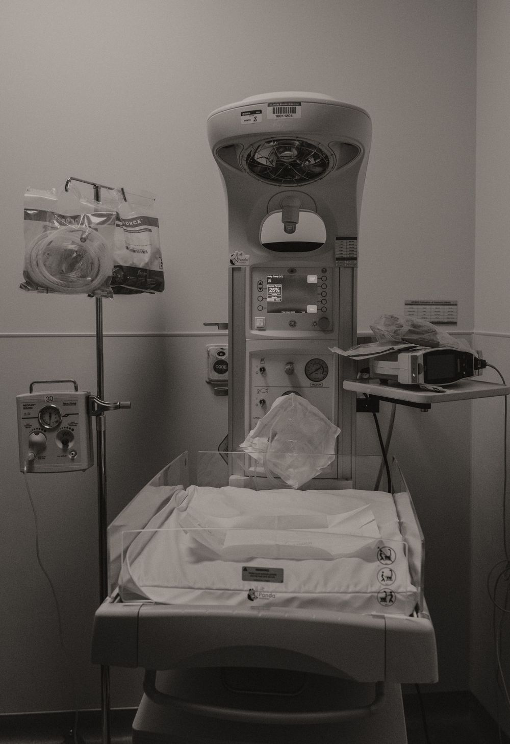 Empty hospital bed with medical equipment and monitors in a clinical setting.