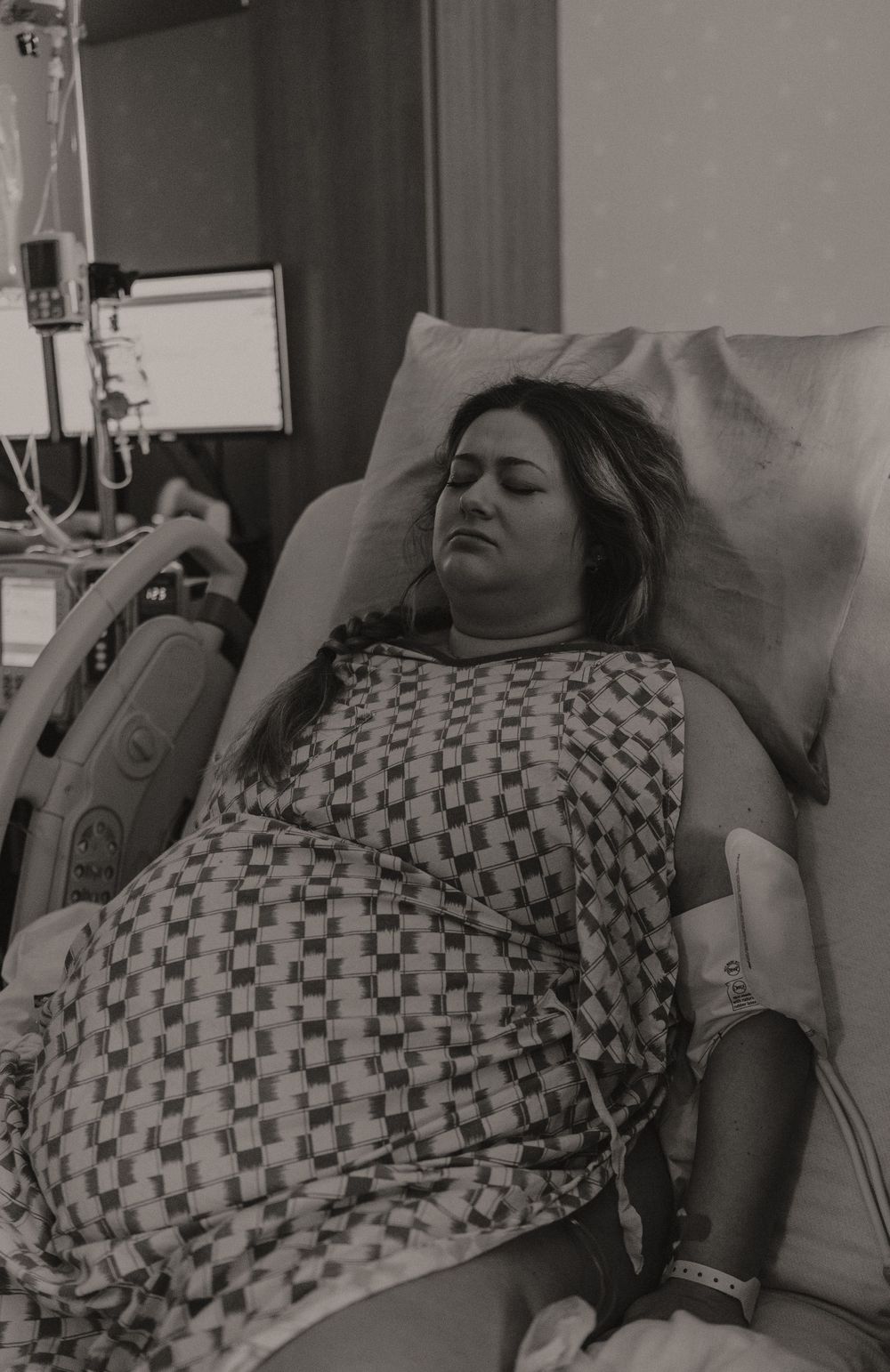 Patient resting in hospital bed with medical equipment visible.