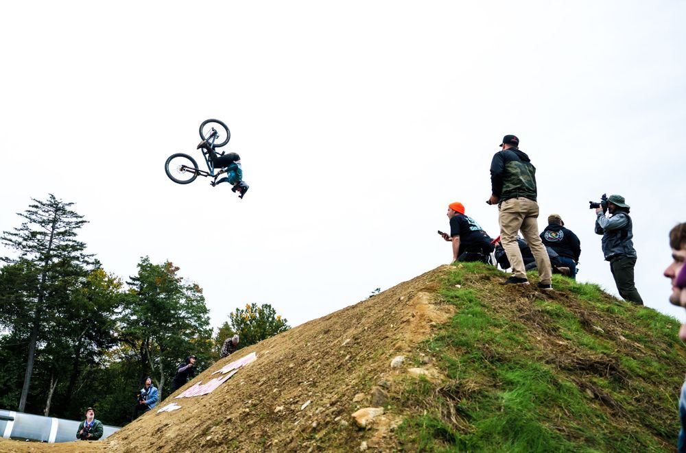 A bike rider does a backflip at the Redbull Best Whip Event at US MTB Open in Vermont at Killington