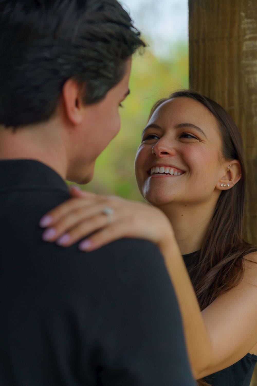 A couple shares intimate moments and laughter under a covered walkway.
