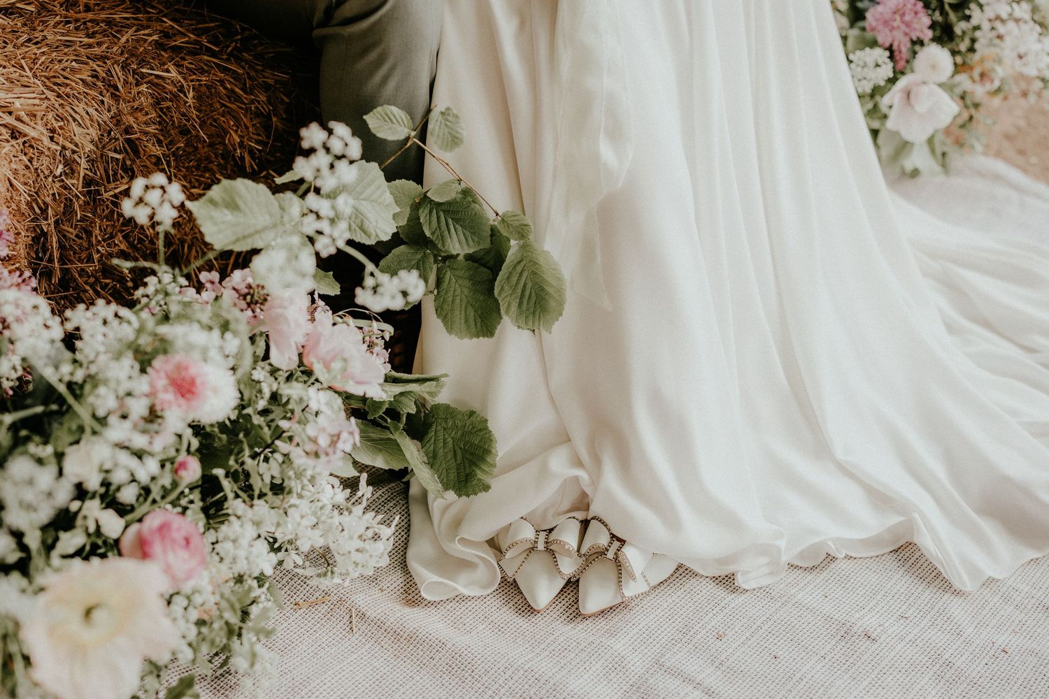 Wedding stationery and details artistically arranged on flowing white tulle fabric.