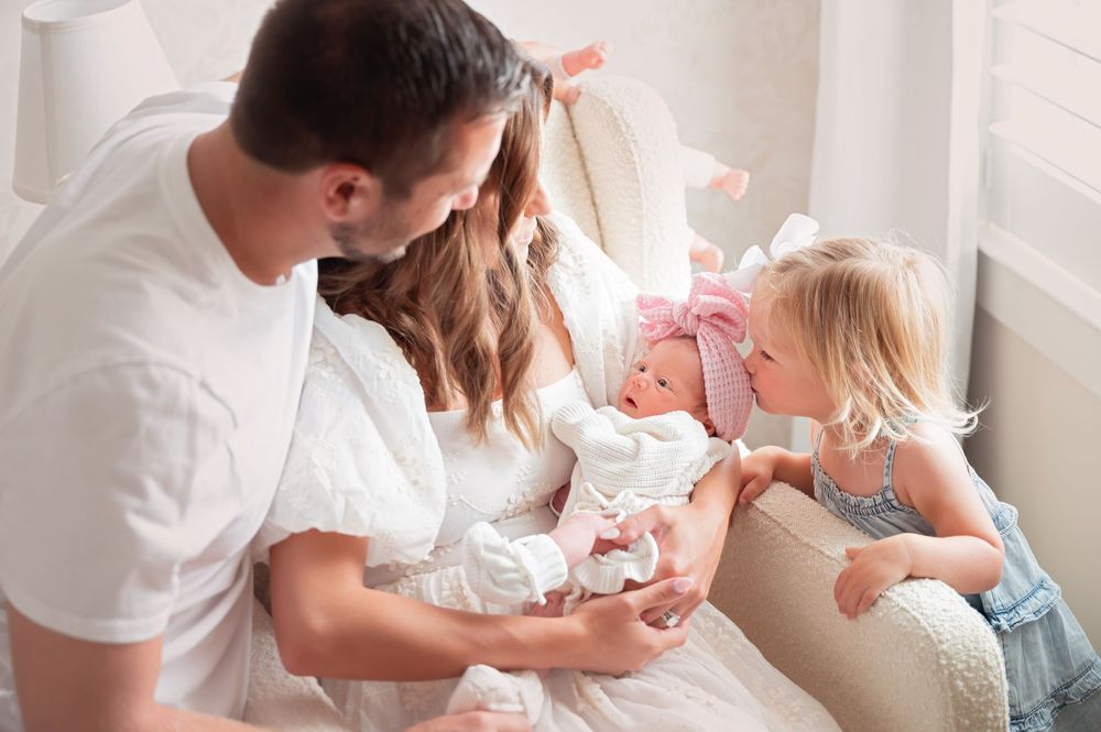 Parents lovingly cradle and feed their sleepy newborn baby in a peaceful nursery setting.