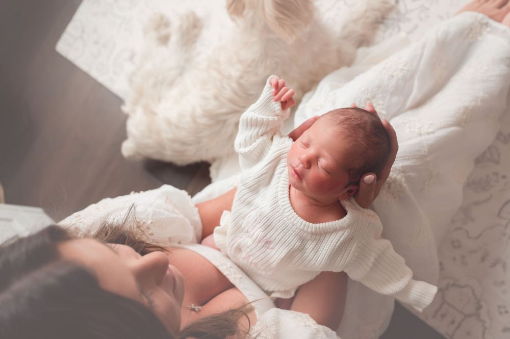 Seven tender newborn photos showing an infant wrapped in soft white blankets against neutral backgrounds.