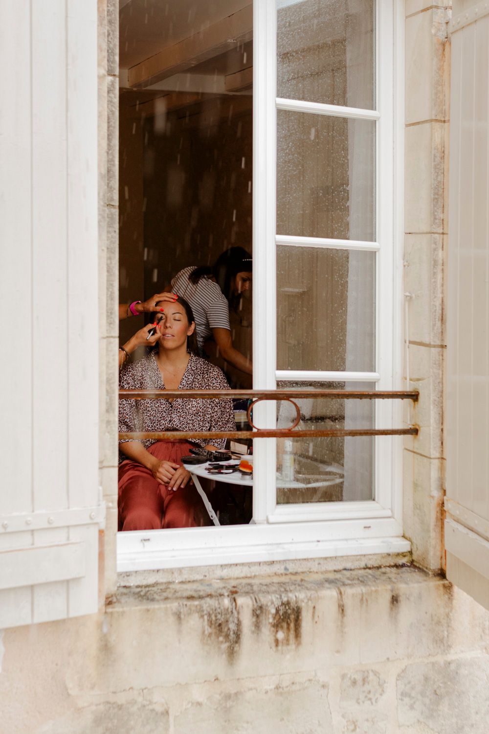 Maquillage de mariée au Logis de La Grosse Pierre à travers la fenêtre