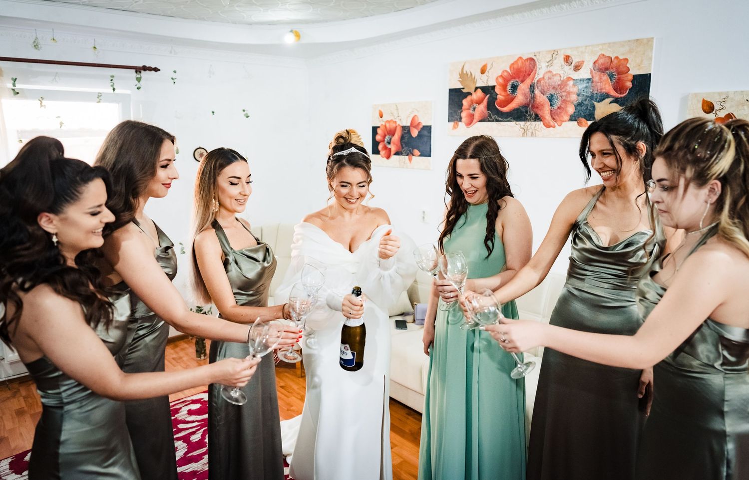 Wedding party members in sage green dresses share joyful moments during pre-ceremony preparations.