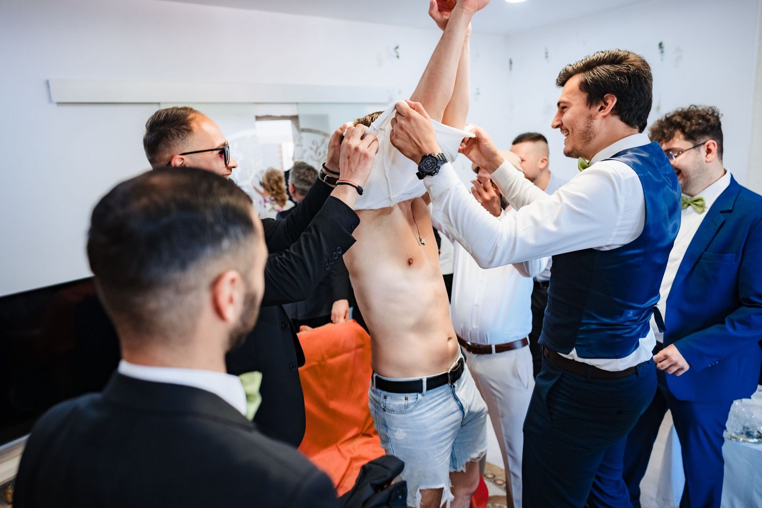 Groomsmen in suits and formal attire participating in pre-wedding festivities.