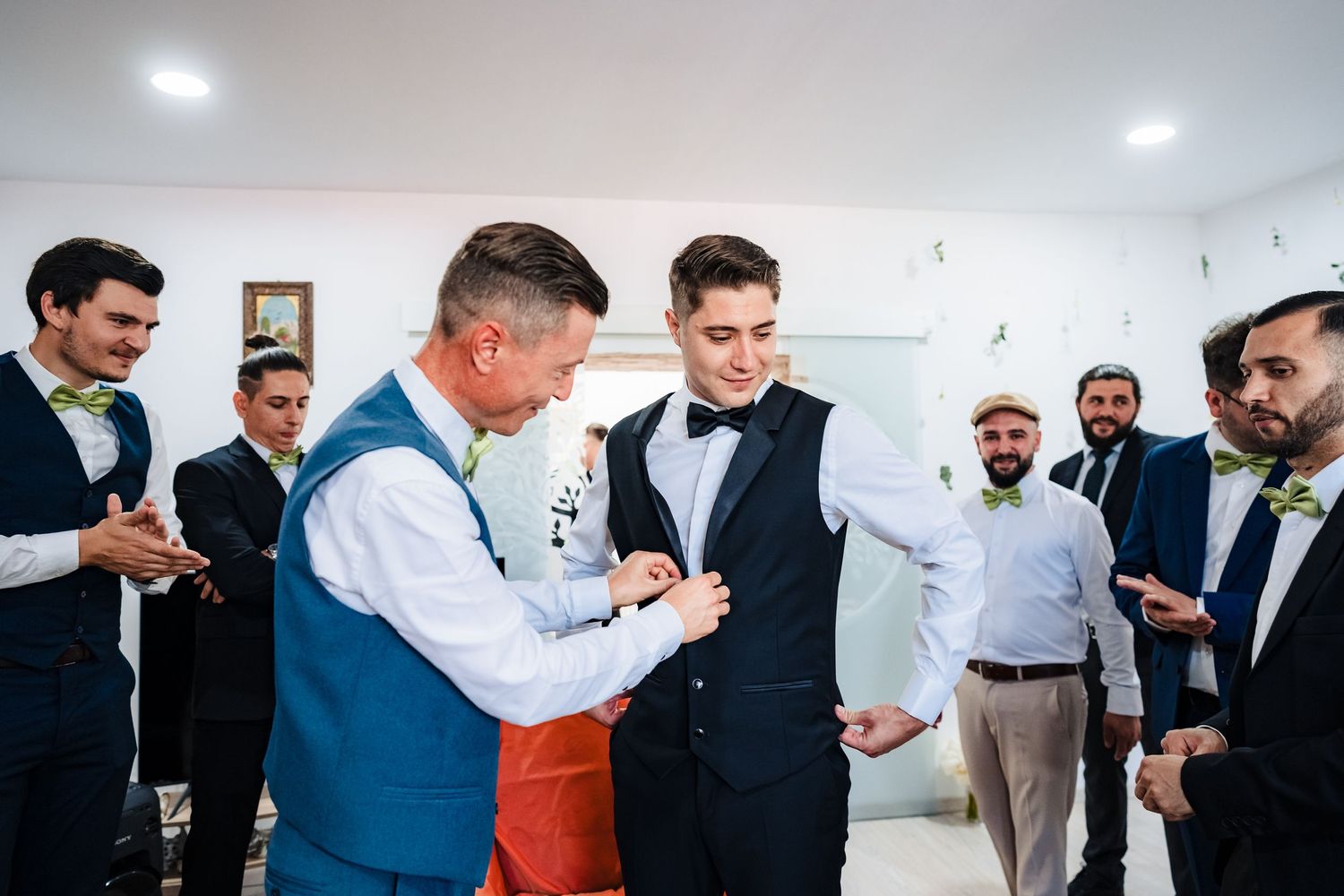 Group of well-dressed men celebrating with drinks in a modern room.