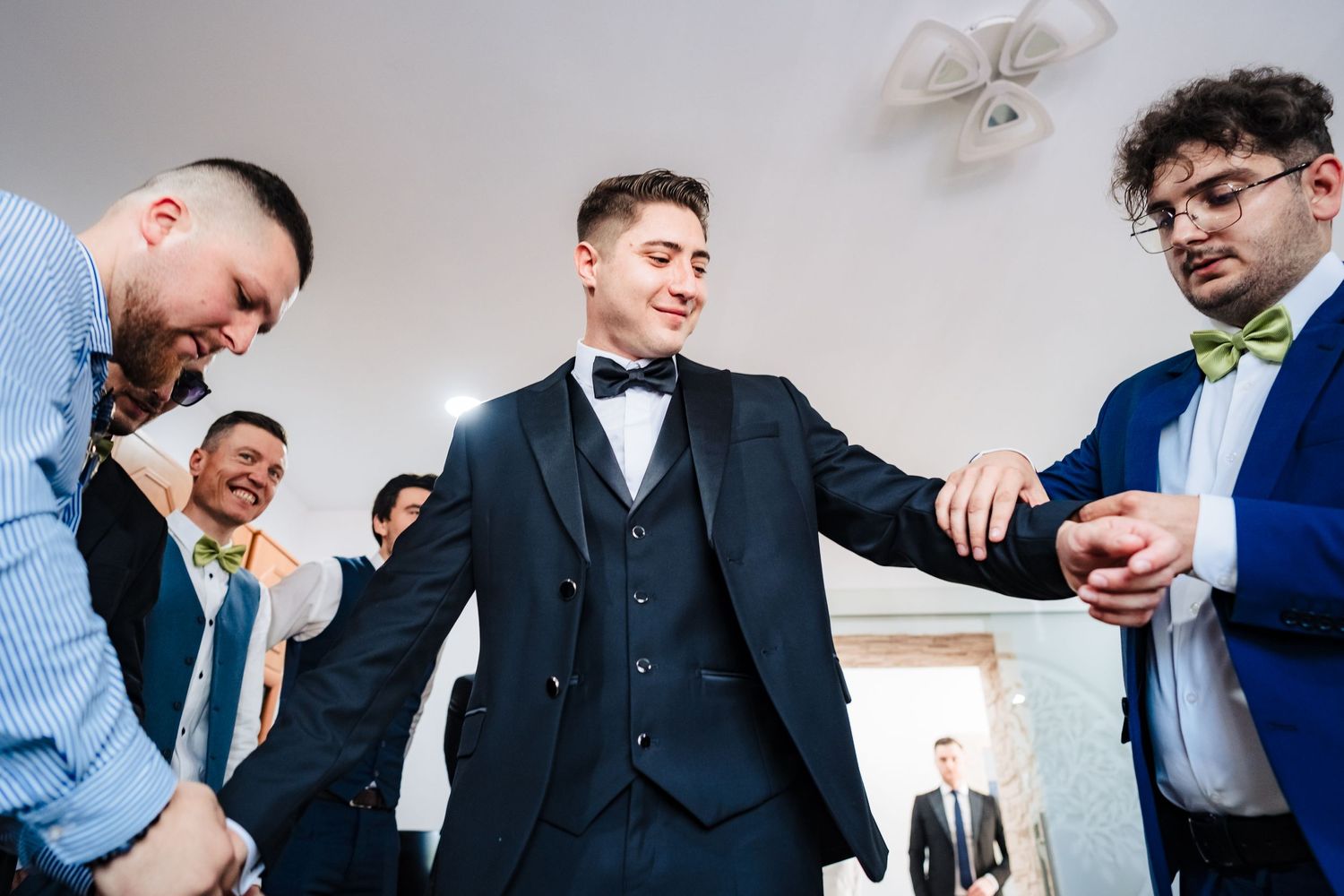 Wedding party members toasting with shots in a bright indoor setting.