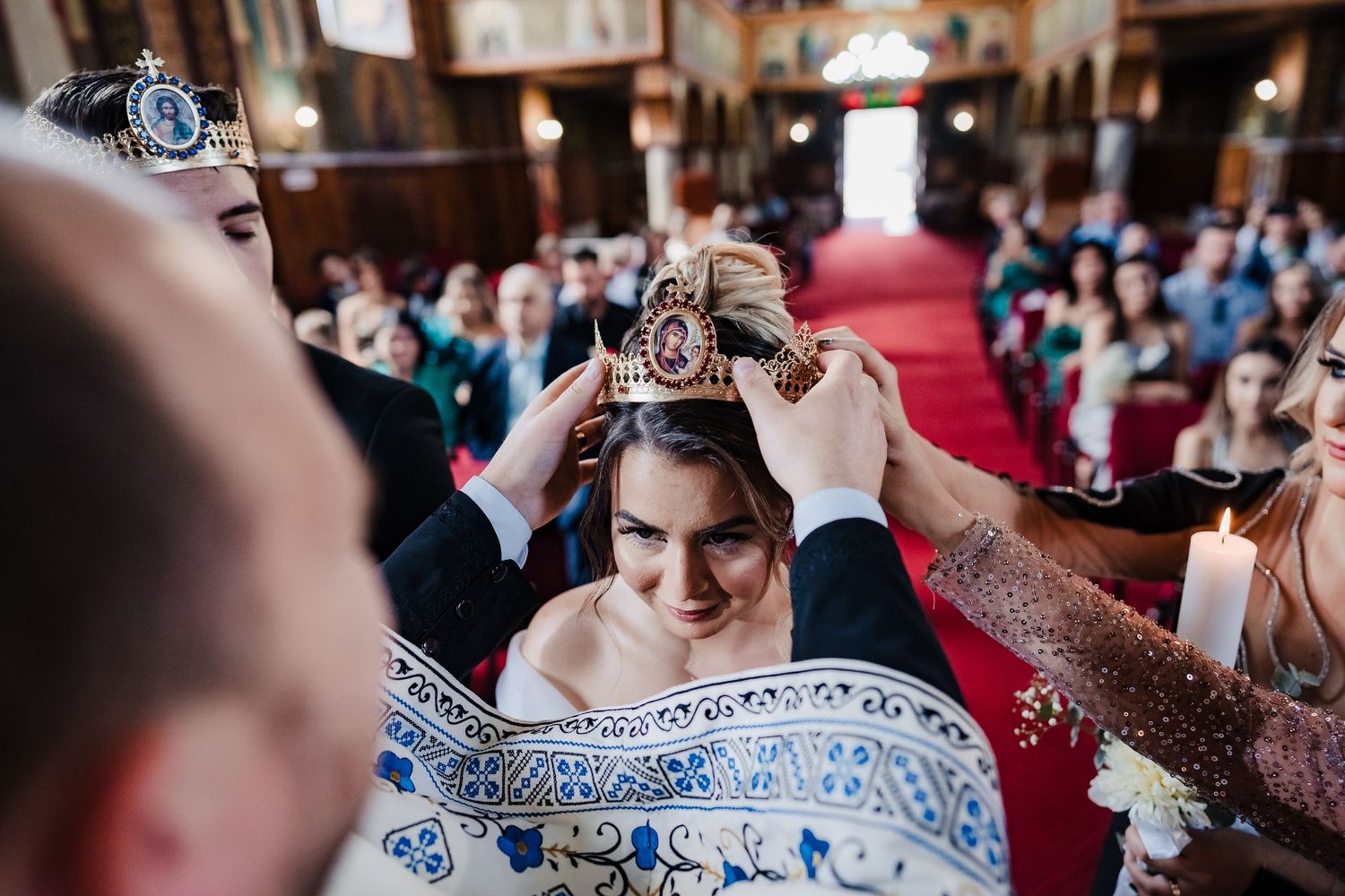 Traditional crowning ceremony during Orthodox wedding with ornate church details visible.