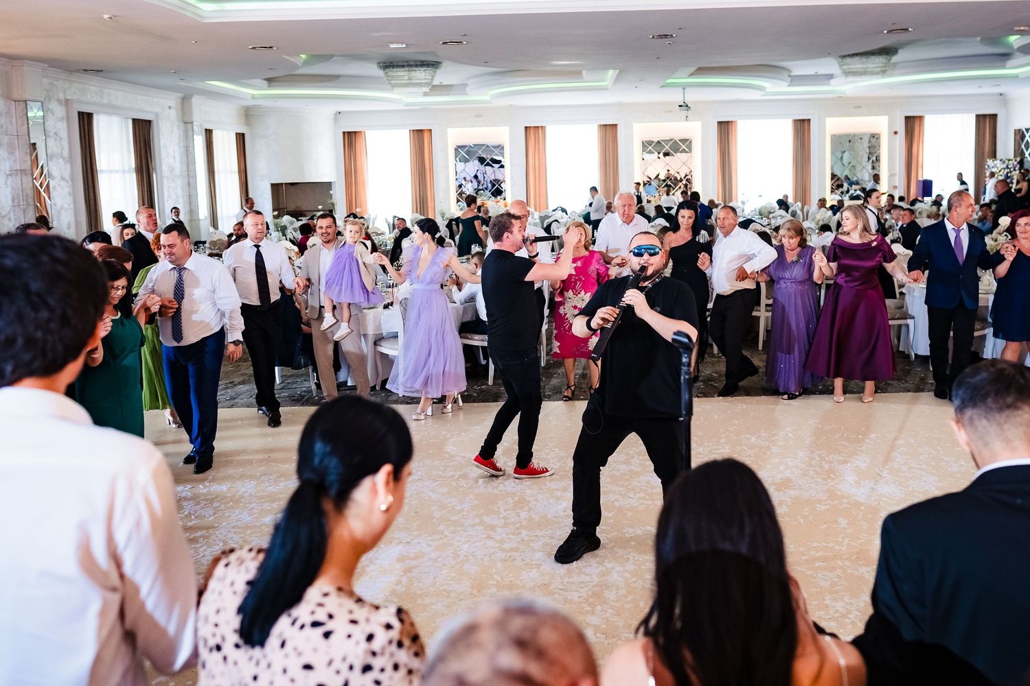 Large group of dancers fill a spacious ballroom during an elegant social event.