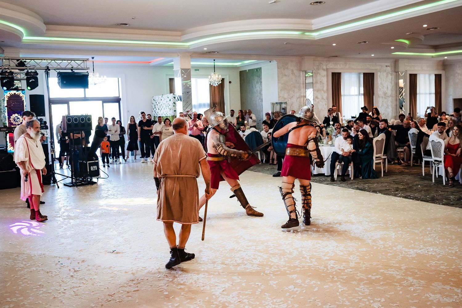 Costumed performers stage a medieval combat scene during wedding reception entertainment.