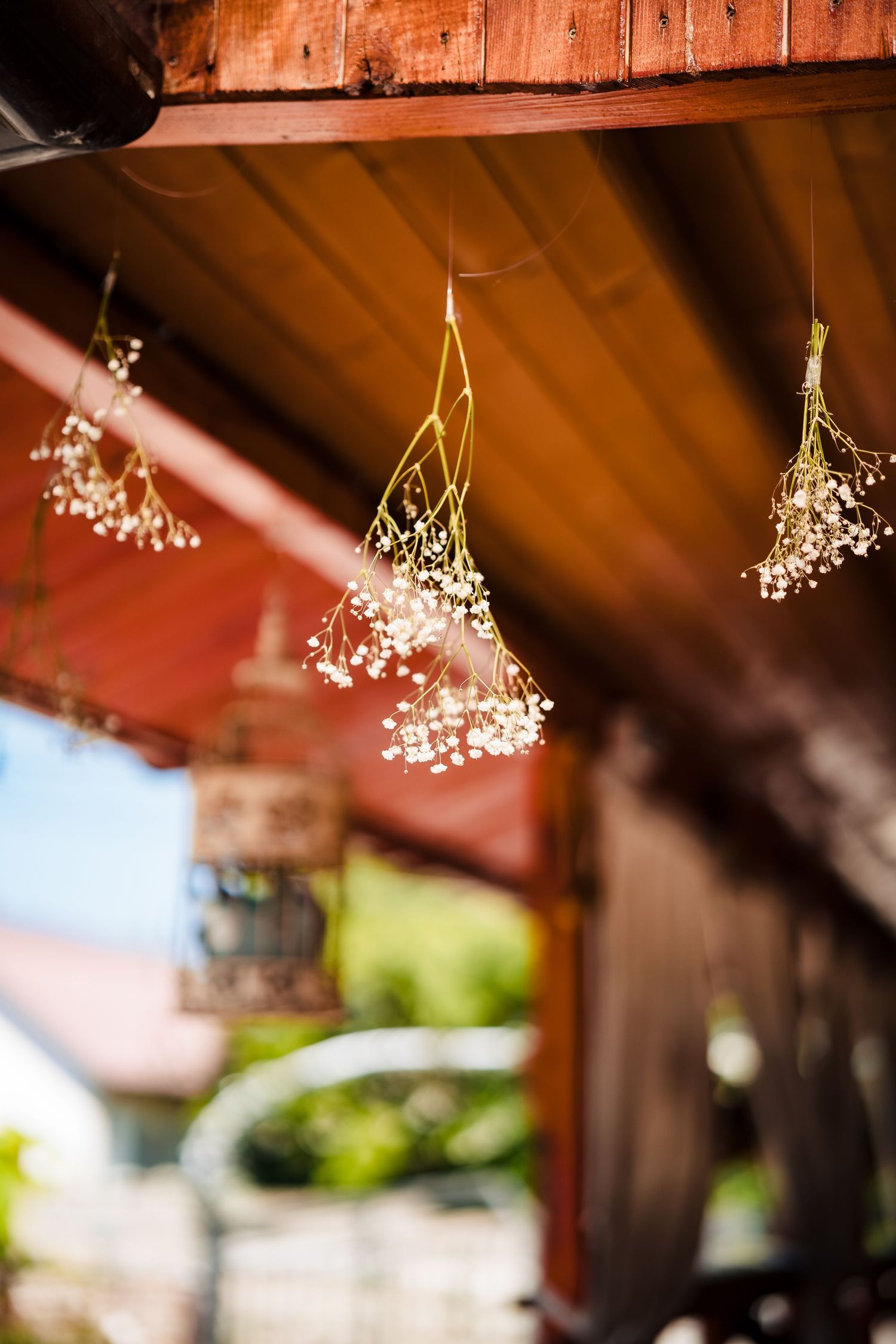 Rustic wooden beams decorated with hanging baby's breath flowers create romantic wedding ambiance.