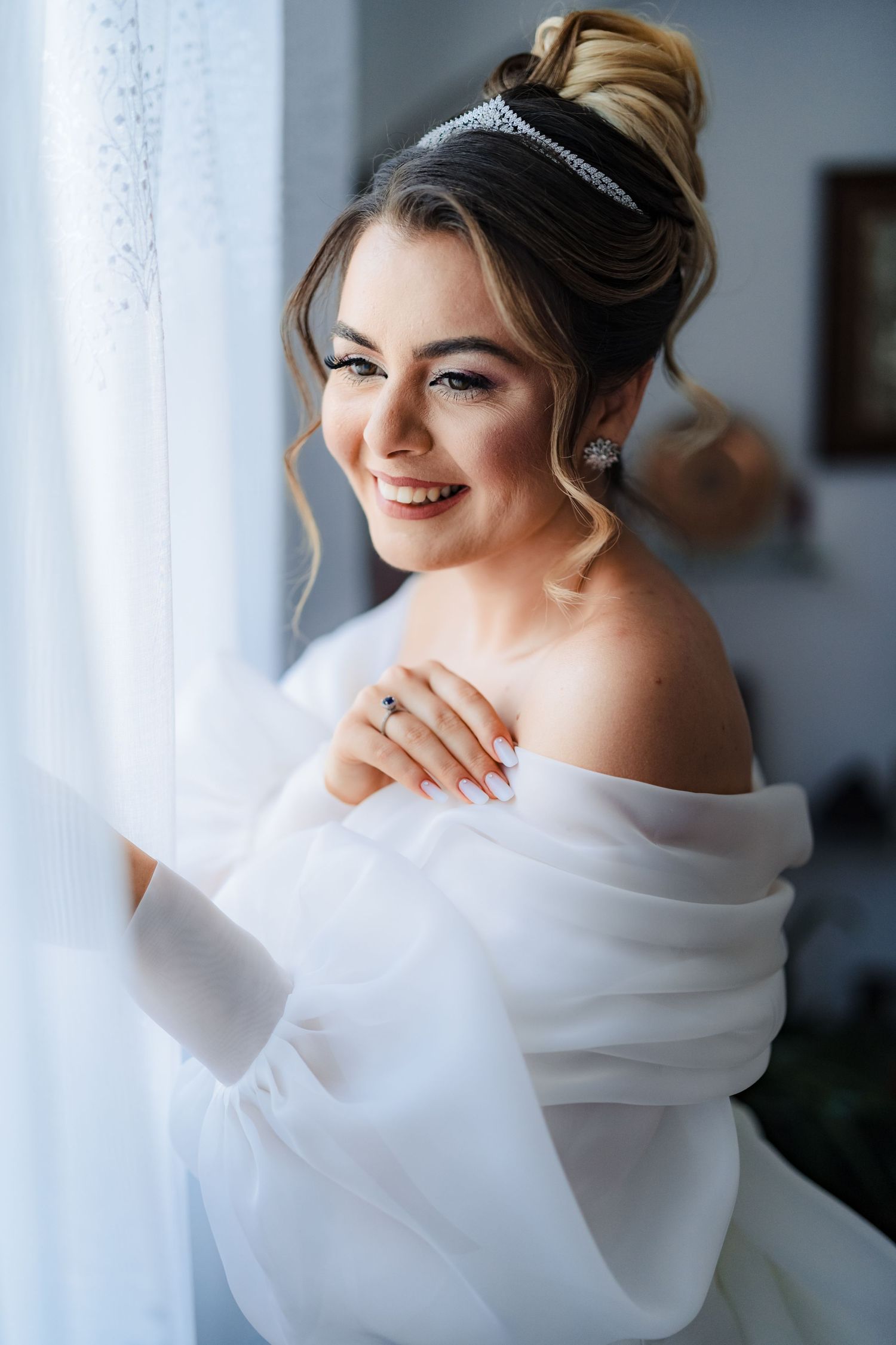 Elegant white wedding gown detail with off-shoulder design against light background.