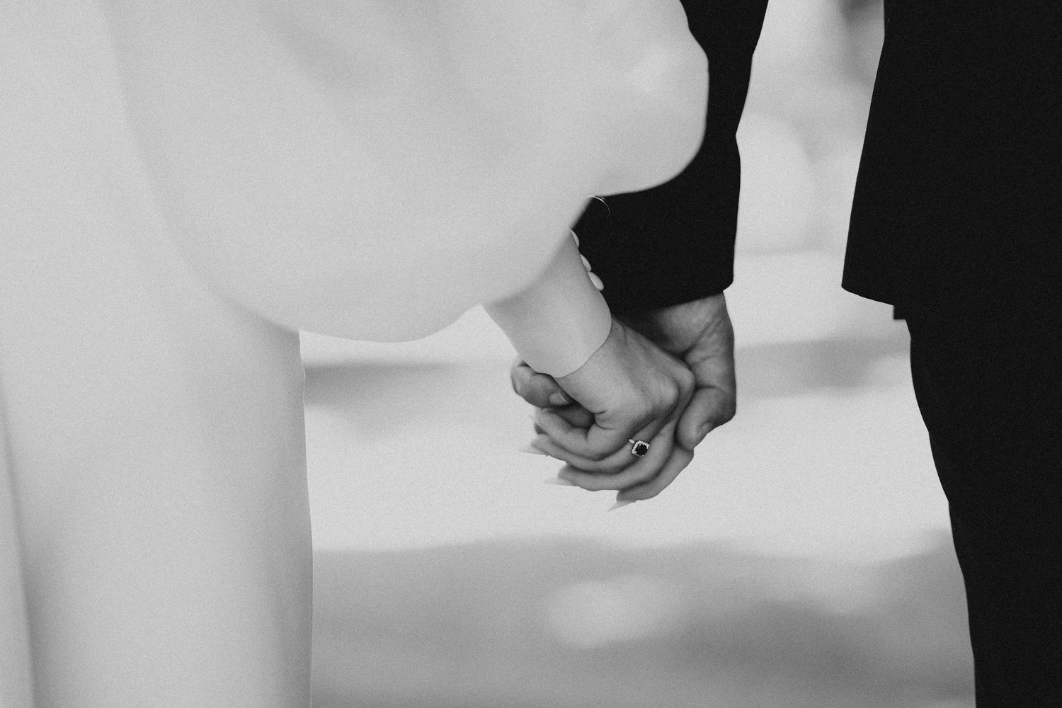 A couple holds hands during their wedding ceremony in front of an ornate altar.