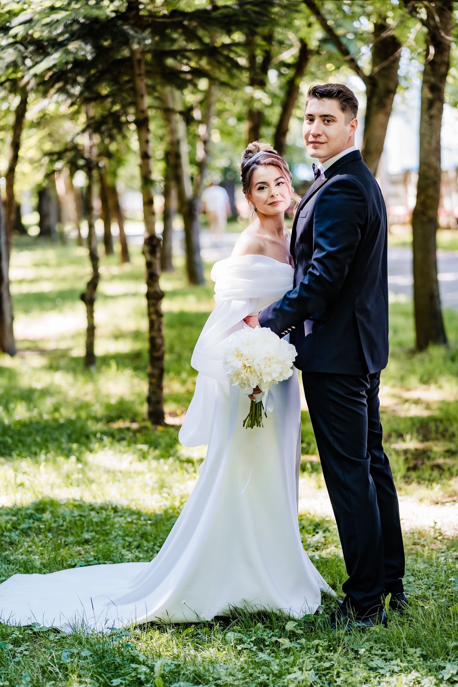 Wedding photography sequence in a sunlit park with elegant white gown and classic suit.