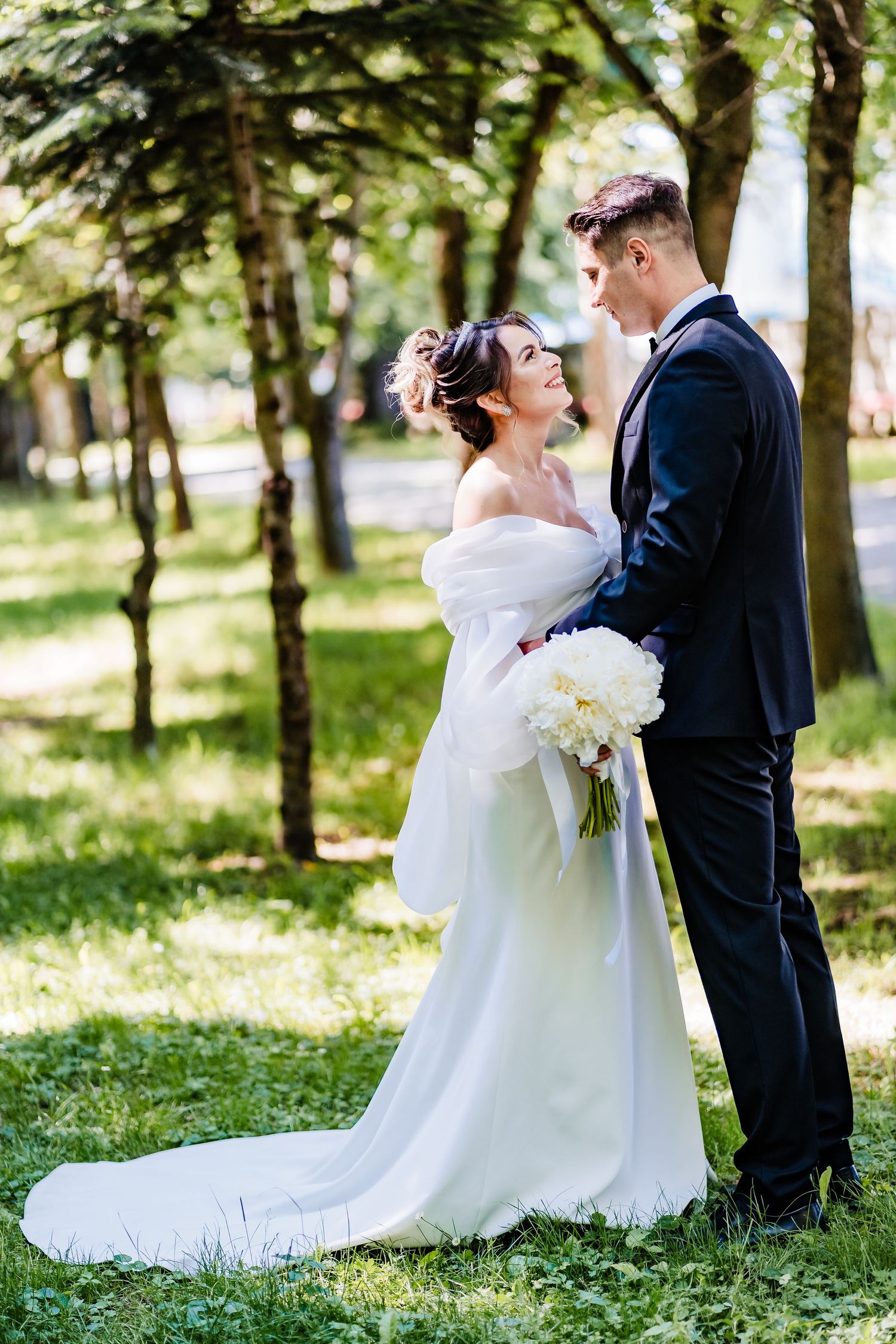 Romantic wedding photo series captured in a lush green park setting.