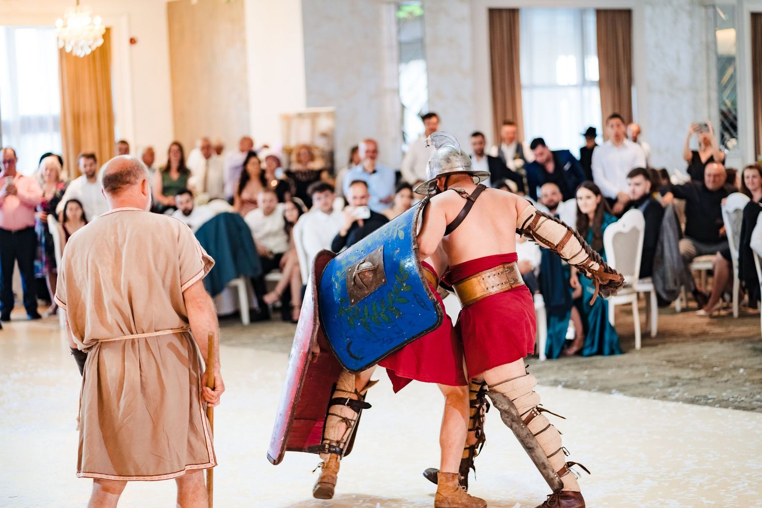 Wedding guests dance together during a lively reception celebration on a spacious dance floor.