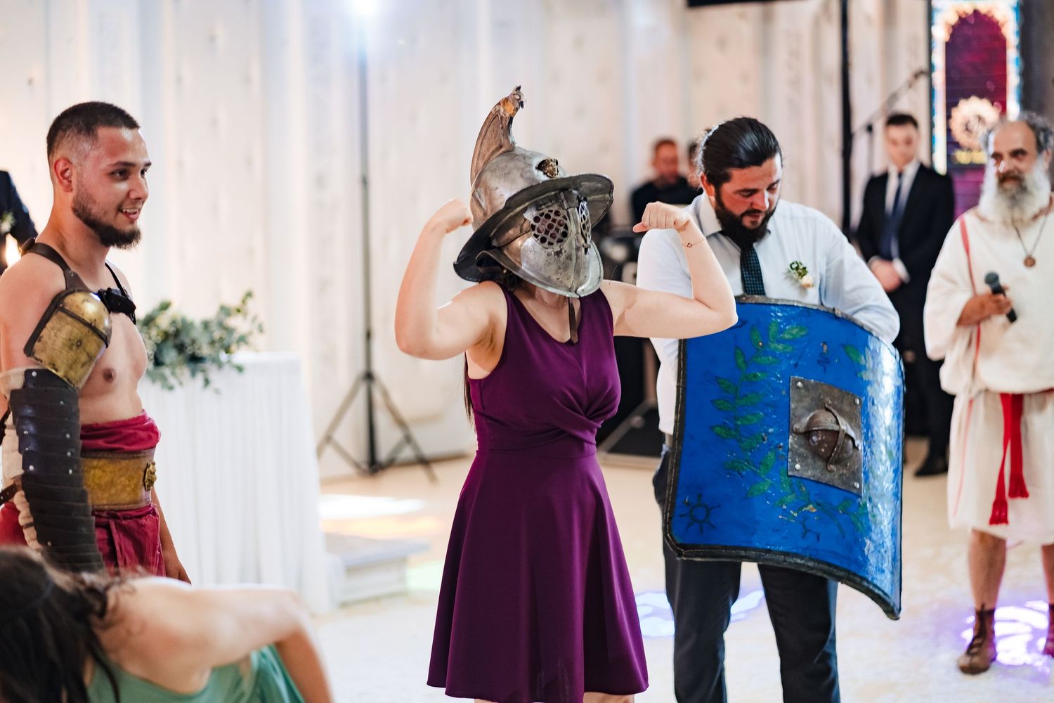 Costumed performers in medieval warrior outfits entertain guests at themed wedding reception.