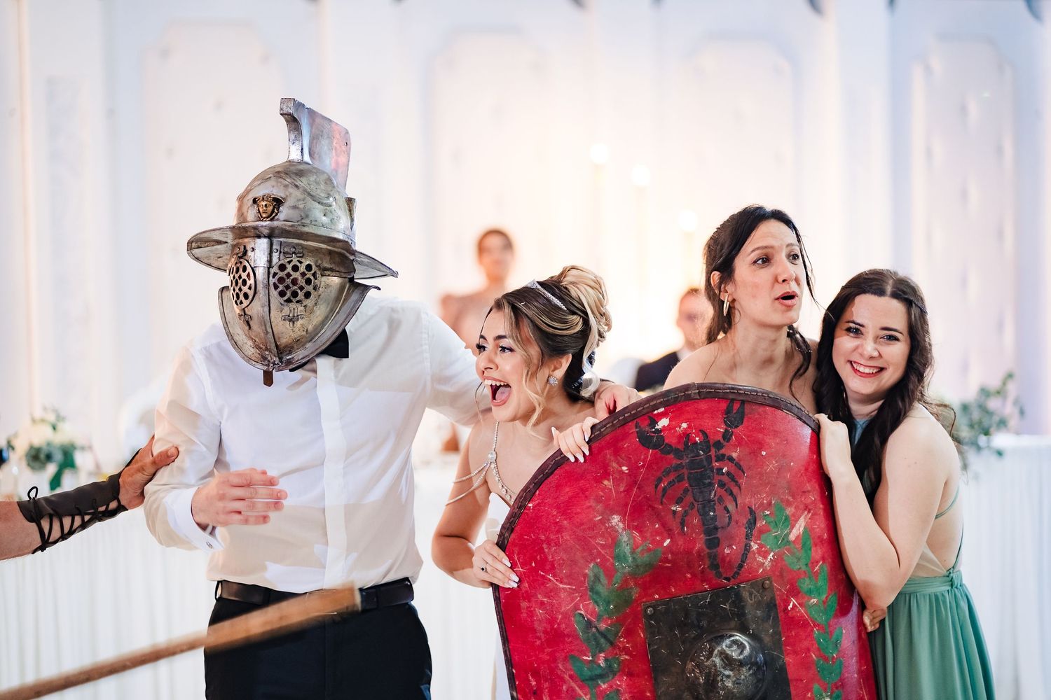 Dancers perform energetic moves at an elegant event with white draping and decorative lighting.